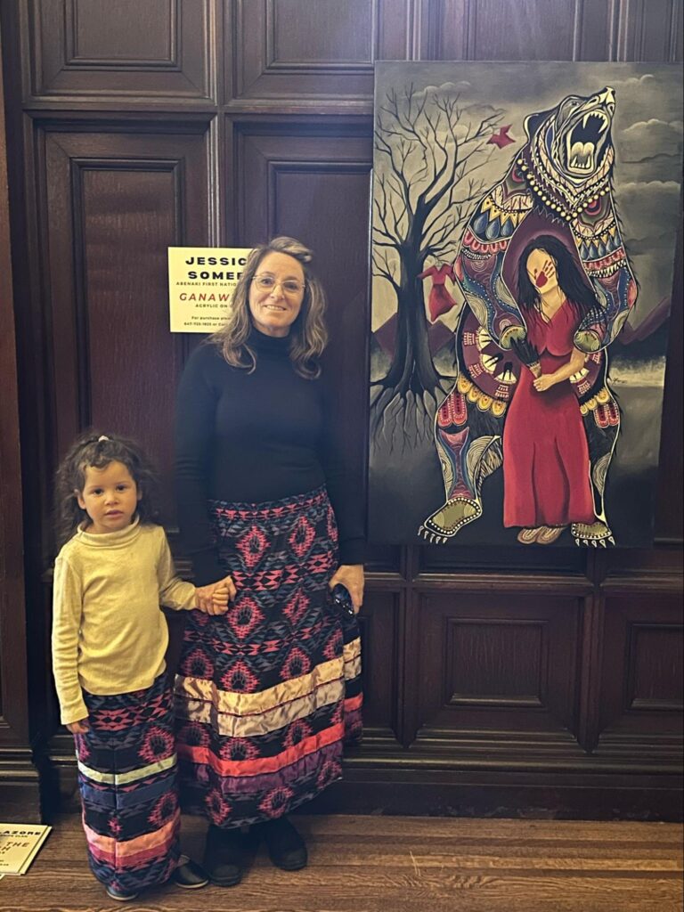 Focal Point Artistry lead artist facilitating a guided discussion and art talk, engaging an audience in the stories and symbolism behind Indigenous Woodland style paintings.