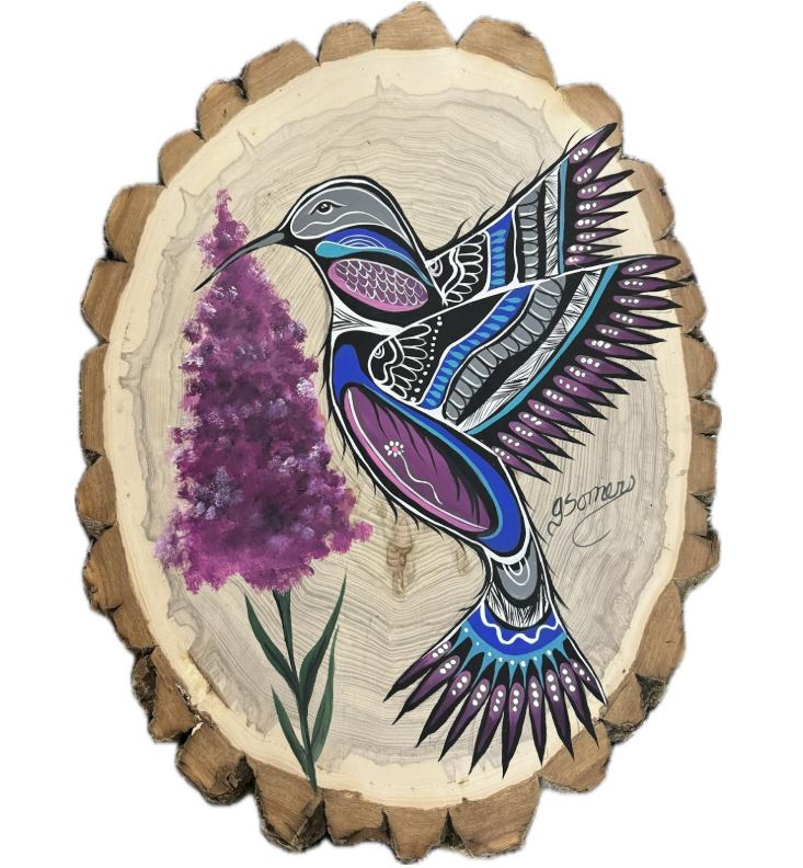 Youth and adults participating in an outdoor land-based learning session led by Jessica Somers, focusing on traditional plant knowledge and Woodland art motifs.